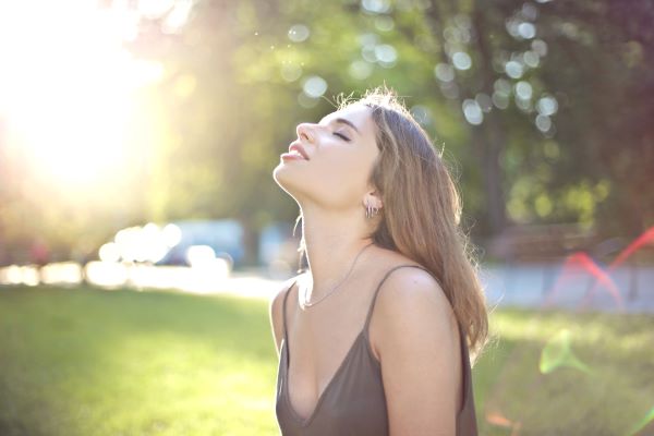 joven-sonriente-respira-aire-fresco-parque