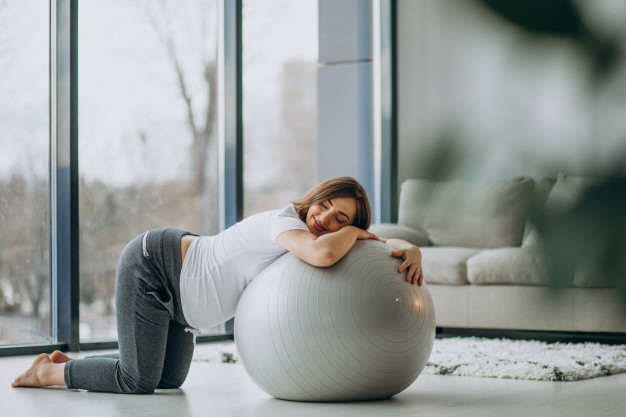 Mujer embarazada reposando en pelota pilates