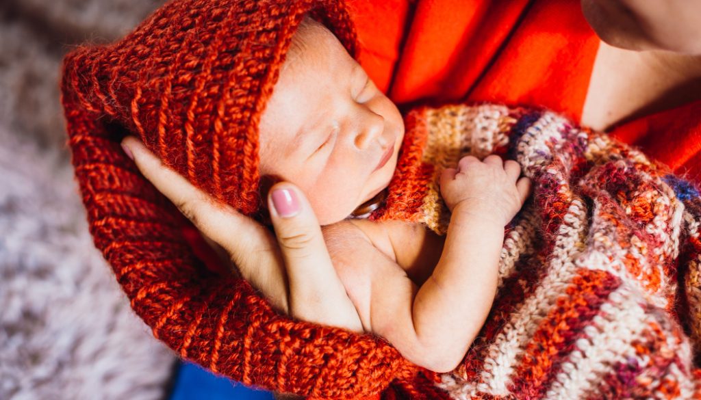 hermoso-nino-sombrero-rojo-duerme-brazos-tiernos-madre