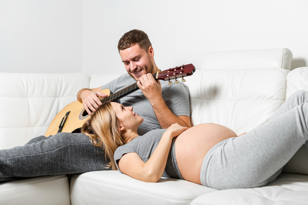 mujer-embarazada-escuchando-su-marido-tocando-guitarra