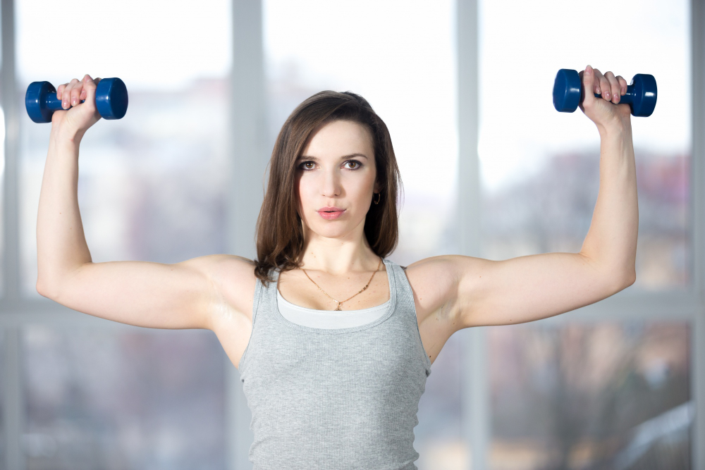 deportivo-joven-mujer-levantamiento-dumbbells