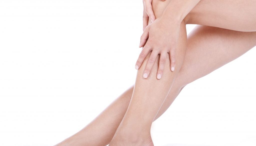 Woman applying moisturizer cream on the legs