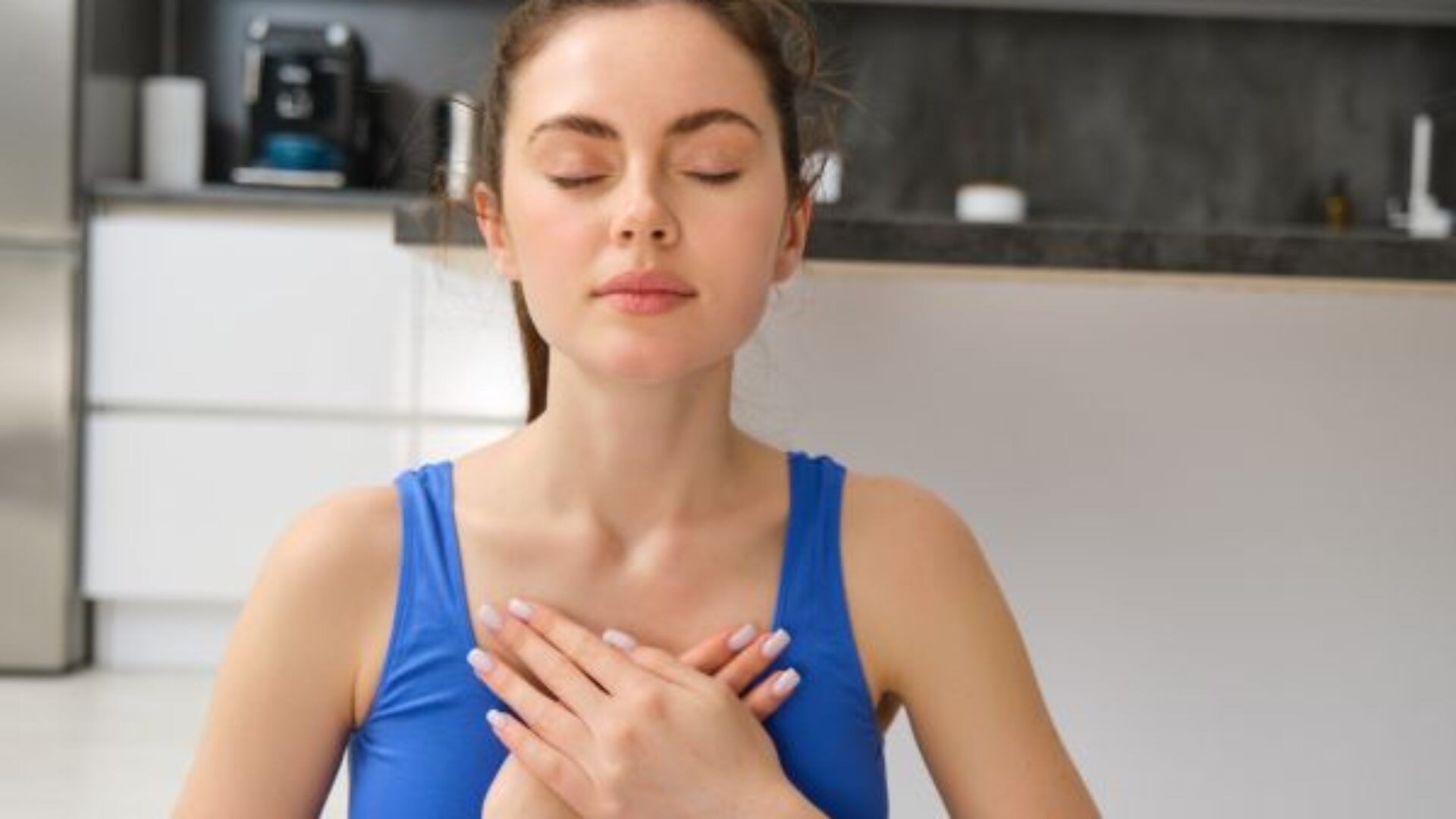 imagen-de-una-mujer-tranquila-y-relajada-meditando-haciendo-practicas-respiratorias-tomandose-las-manos-en-el-pecho-durante